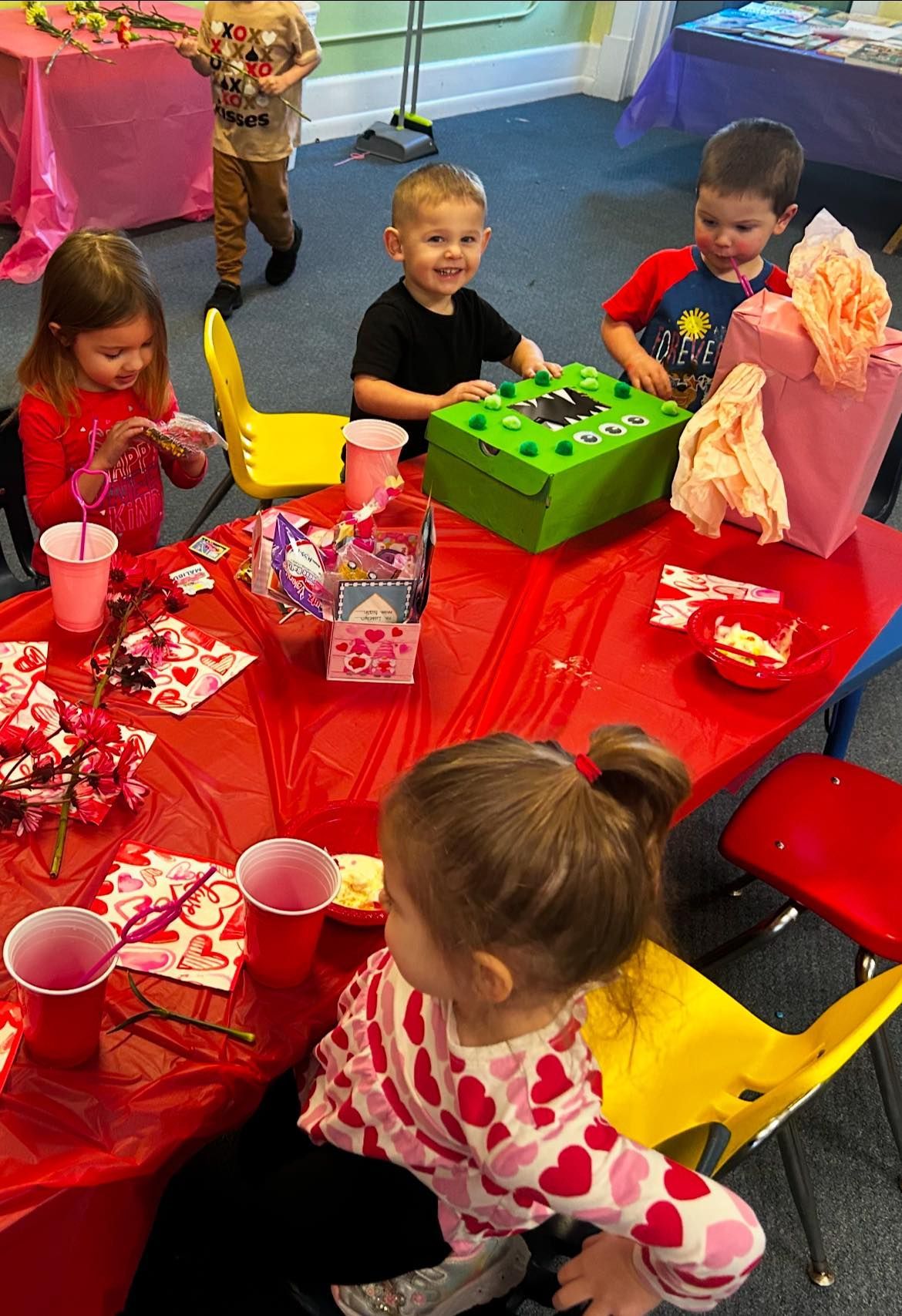 A group of children are sitting at a table at a birthday party.