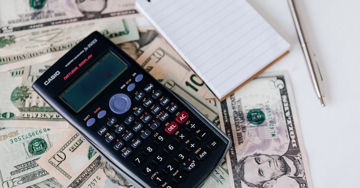 A calculator is sitting on top of a pile of money.