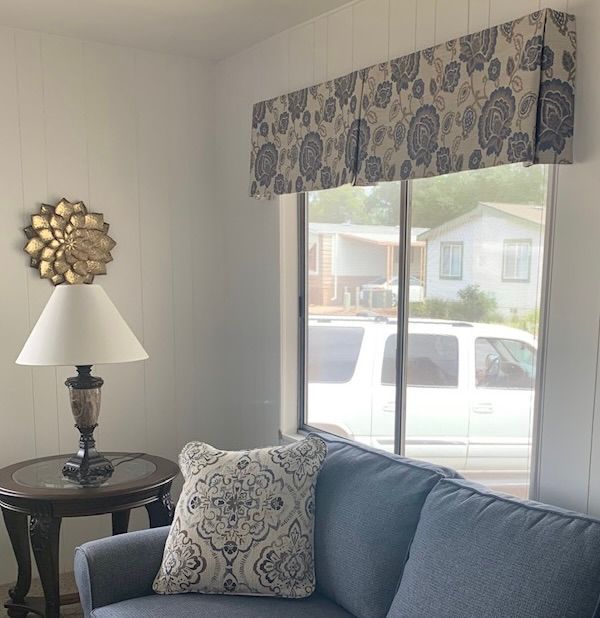 A Living Room with A Blue Couch and A Lamp