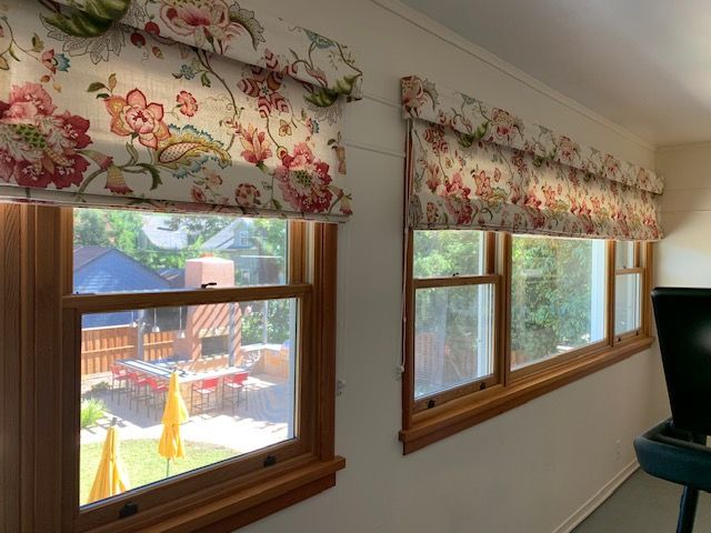 A Room with Two Windows with Floral Curtains on Them