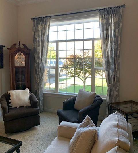 A Living Room with A Clock on The Wall and A Large Window