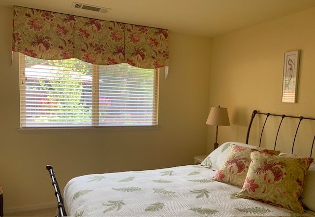 A Bedroom with A Bed and A Window with Blinds
