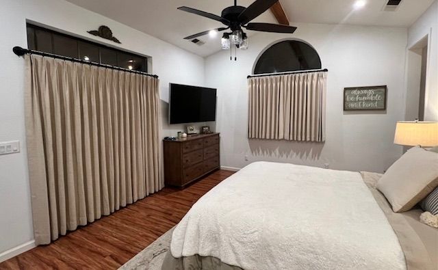 A Bedroom with A Bed , Dresser , Television and Ceiling Fan.