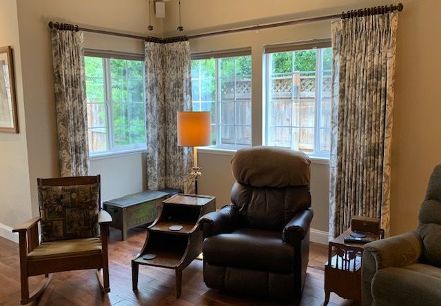 A Living Room with A Recliner , Two Chairs , a Table and A Lamp.