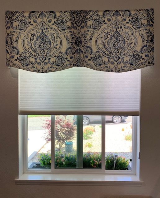 A Window with A Blue and White Valance and A White Blind.