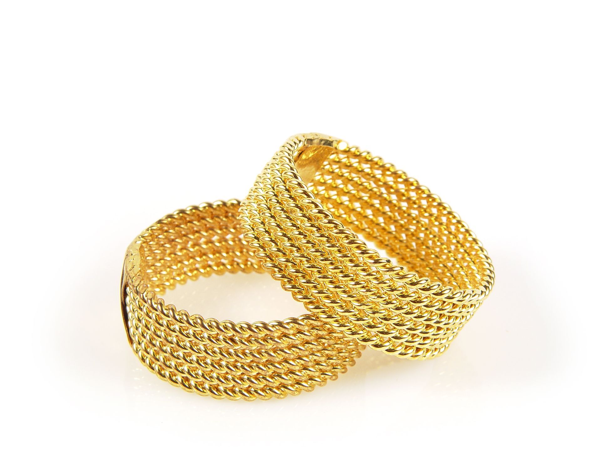 Un paio di braccialetti d'oro su sfondo bianco