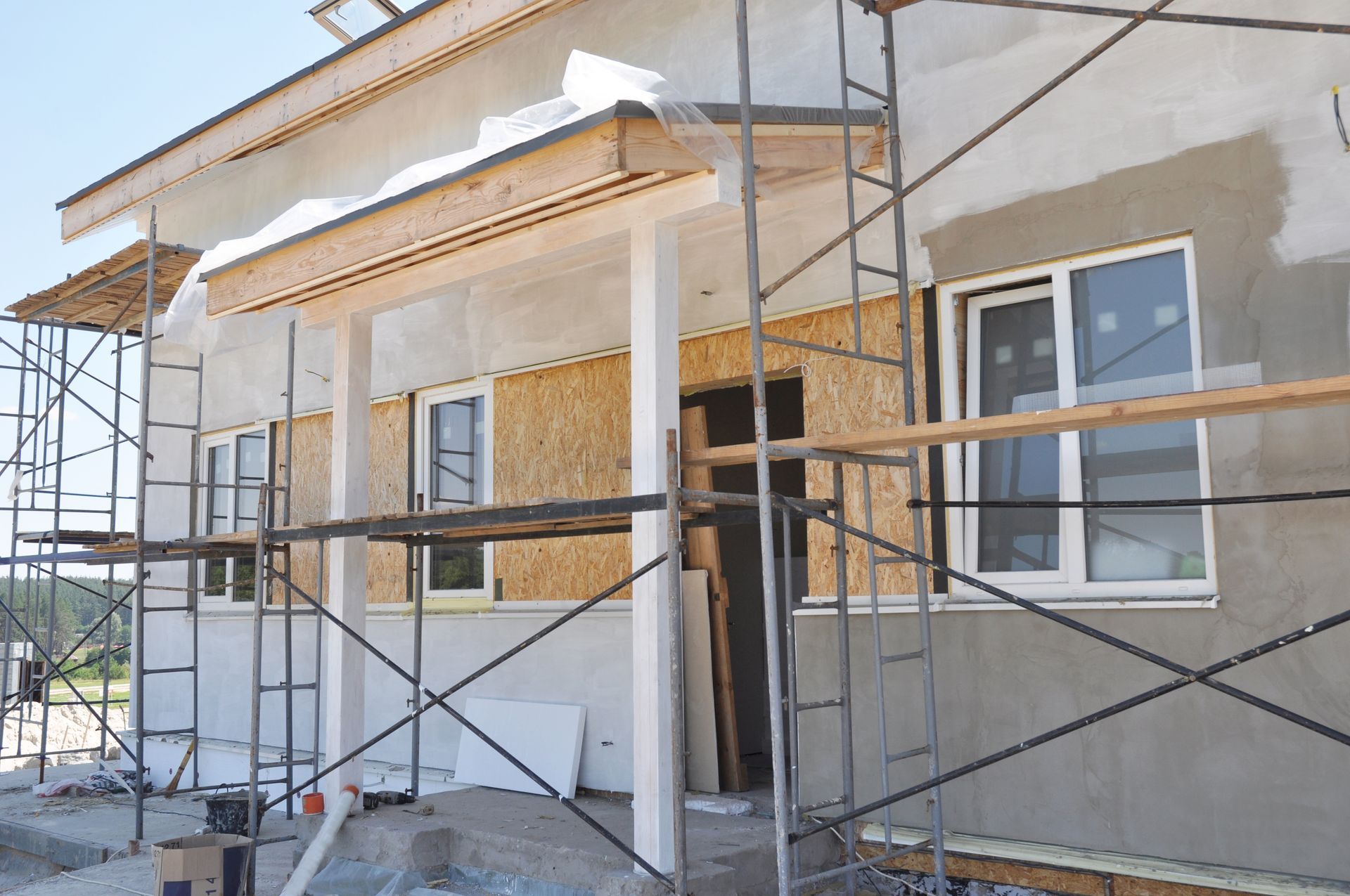 Home exterior remodeling with scaffolding and new wall finish.