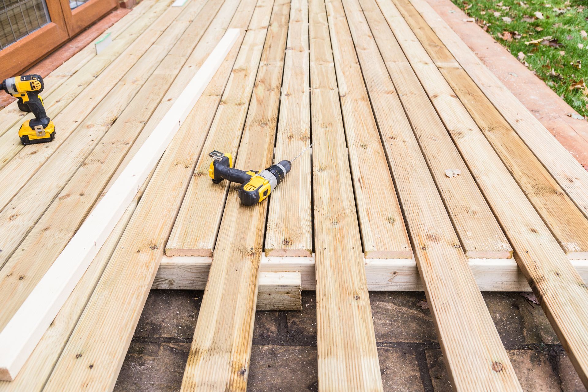 A wooden deck is being built with tools on it.