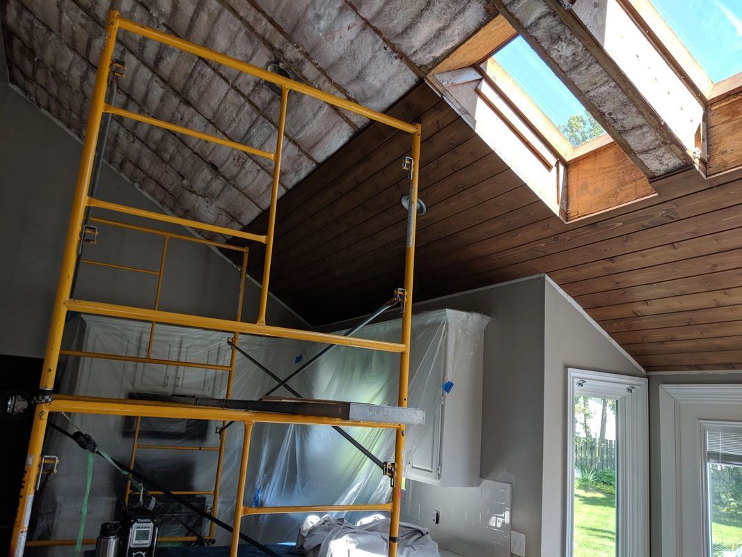 A scaffolding in a room with a skylight in the ceiling