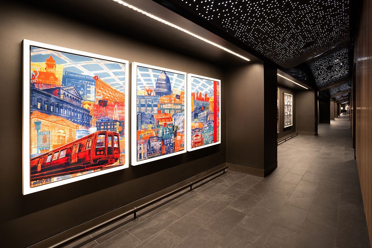 Hallway with black and white wall murals of people, concert scenes, and text.