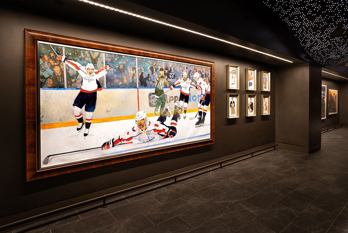 Large colorful mural and seating area in modern building lobby.