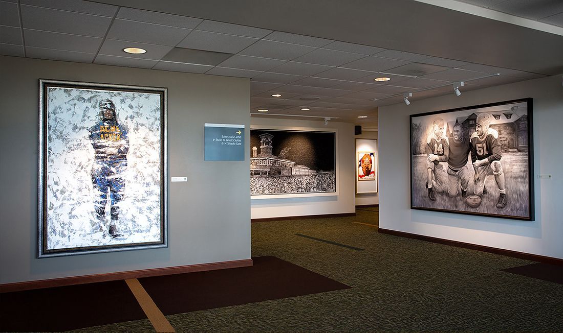 Art gallery interior with framed photographs on display, neutral walls, and carpet.