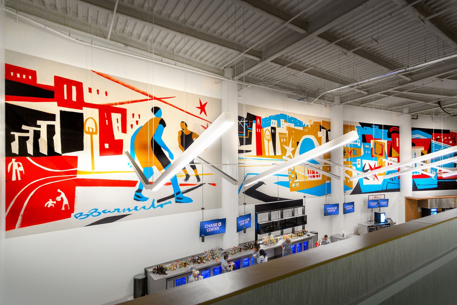 Mural of a person walking, with colorful city buildings. Bright red, blue and yellow design.