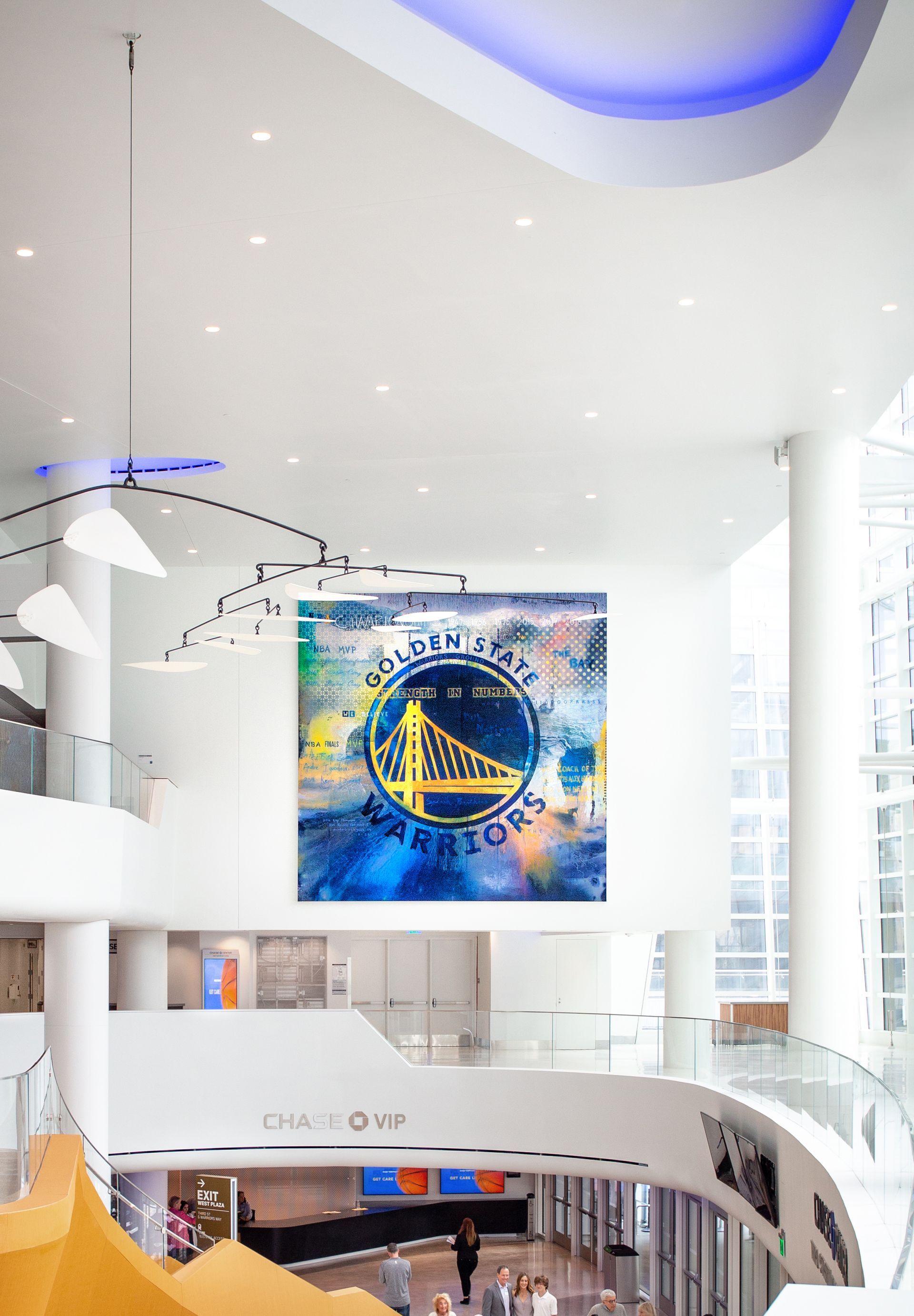 Golden State Warriors logo artwork in a modern, open-plan building.