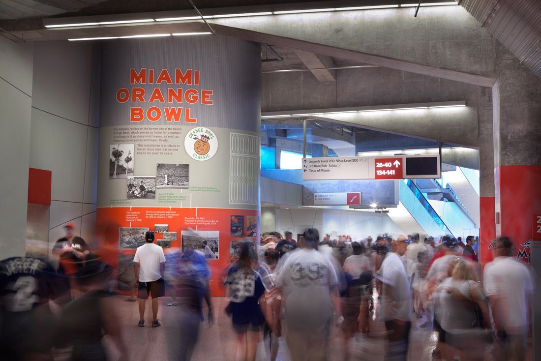 Entrance with crowd passing a pillar displaying