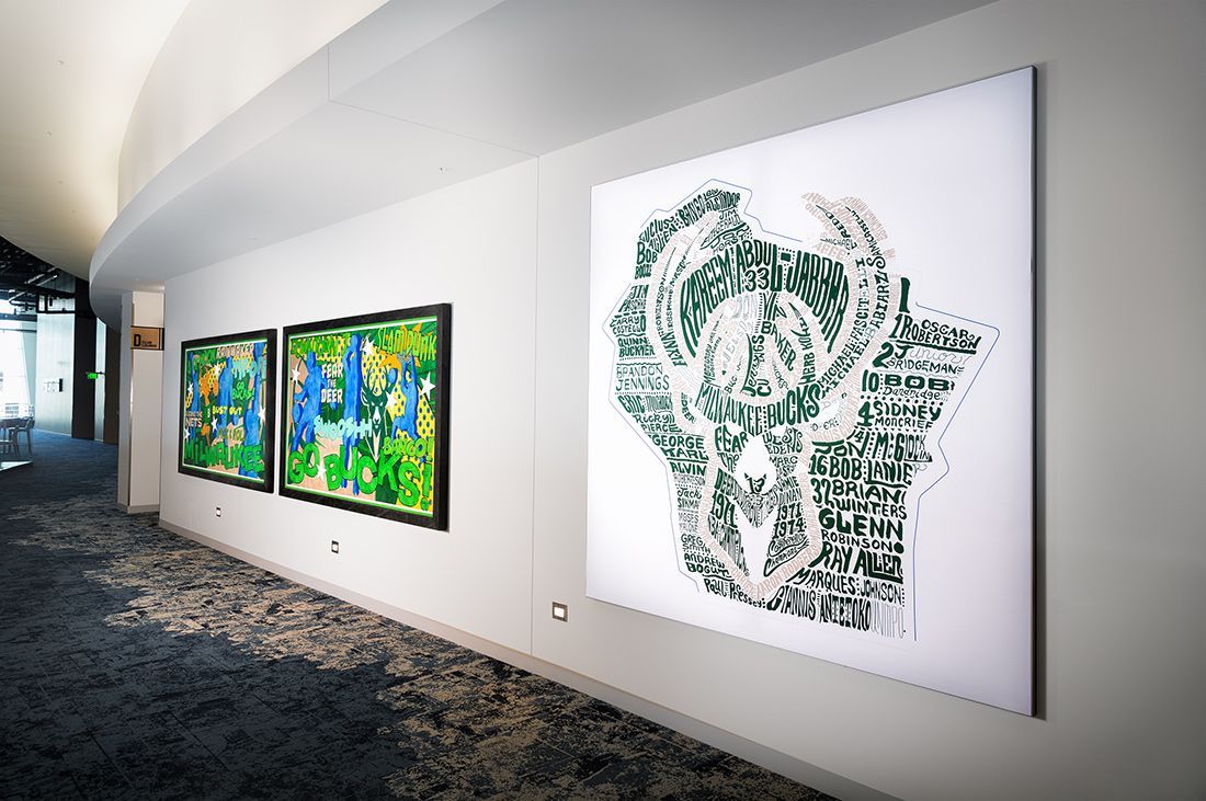 Gallery with white walls, displaying large paintings with colorful and green artwork.