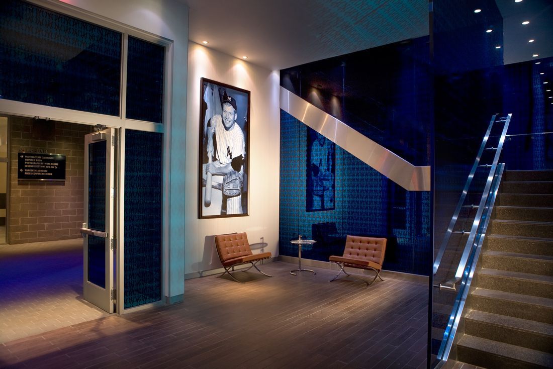 Entrance with a portrait, two chairs, and a staircase. Blue accents, modern design.