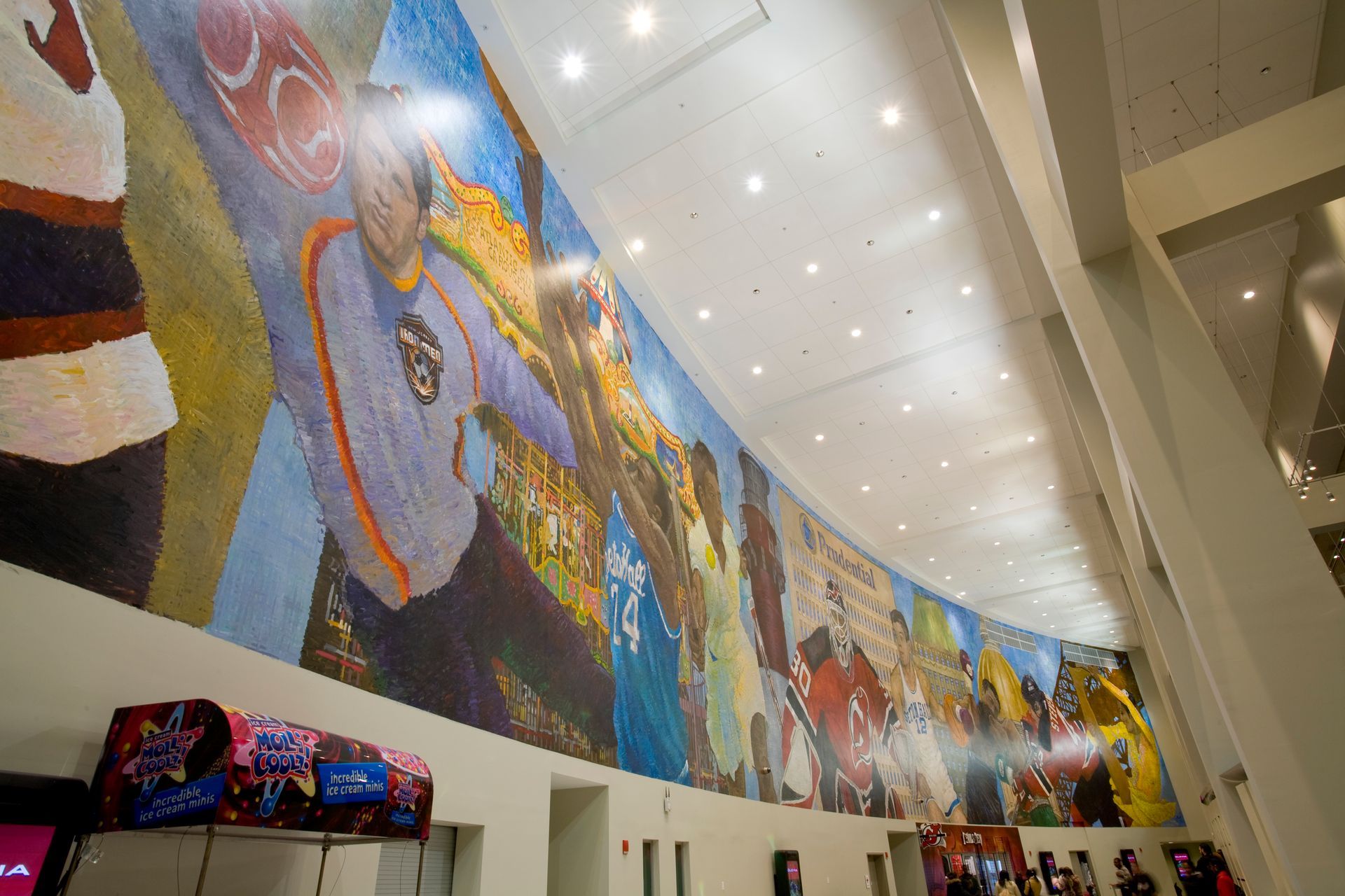 Illuminated decorative metal screen along a building exterior.