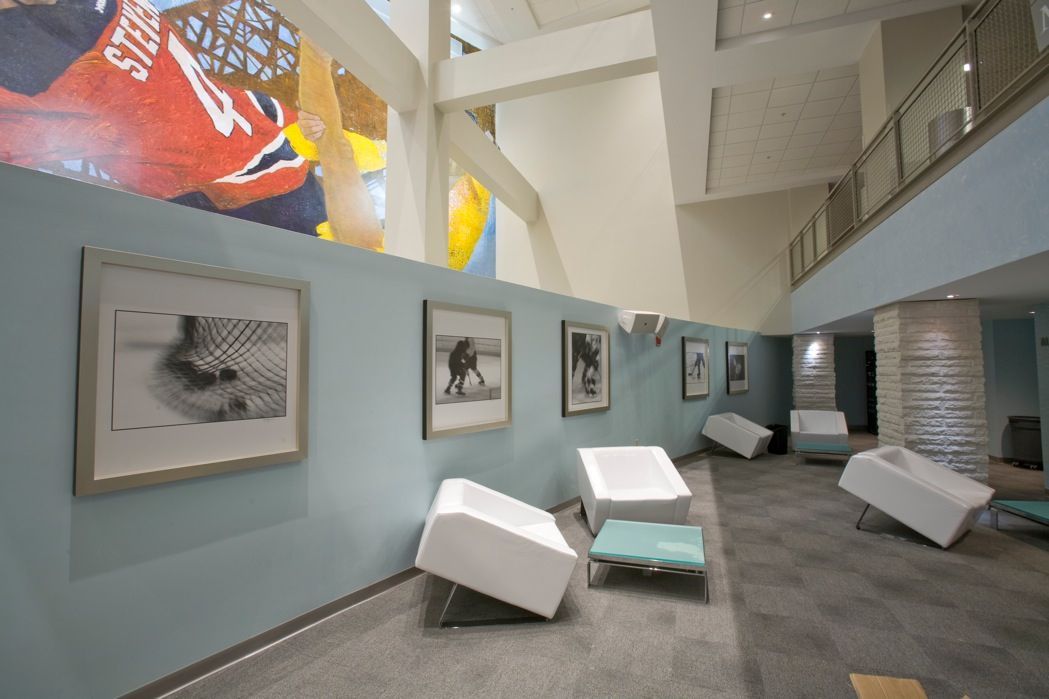 Large colorful mural and seating area in modern building lobby.