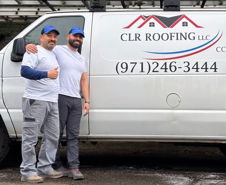 Two men in front of a white CLR Roofing van, one with his arm around the other, both smiling and giving a thumbs up. Two men in front of a white CLR Roofing van, one with his arm around the other, both smiling and giving a thumbs up.