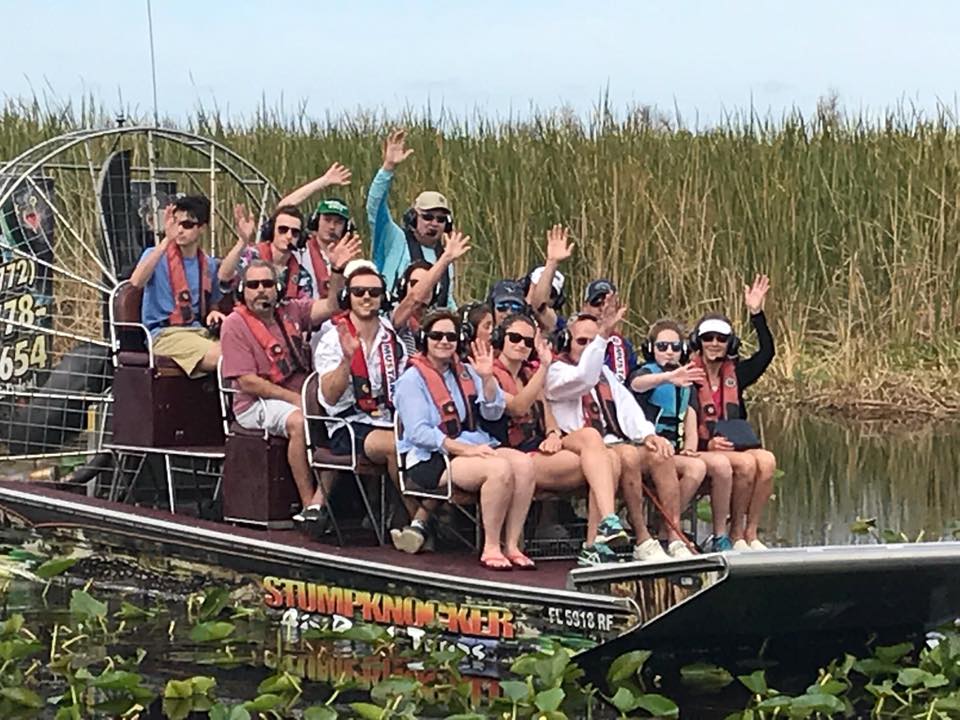 Group of people on the boat while their hands in the air