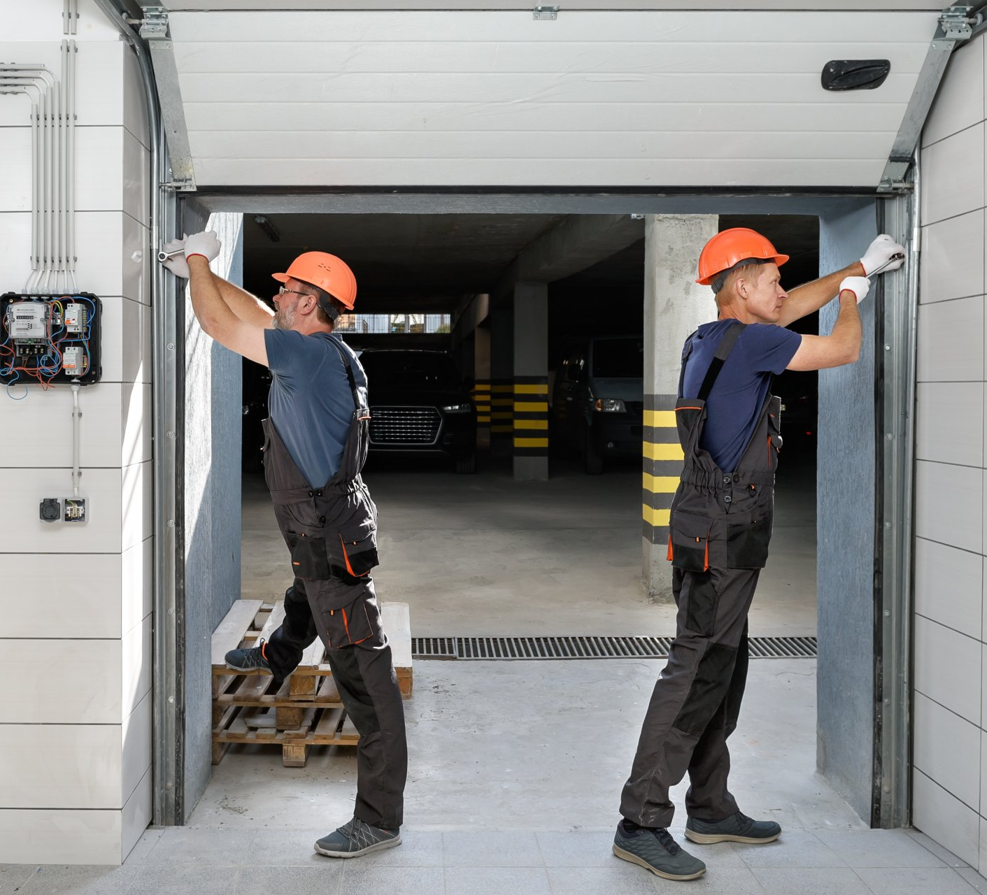 Workers are installing lifting gates of the garage.