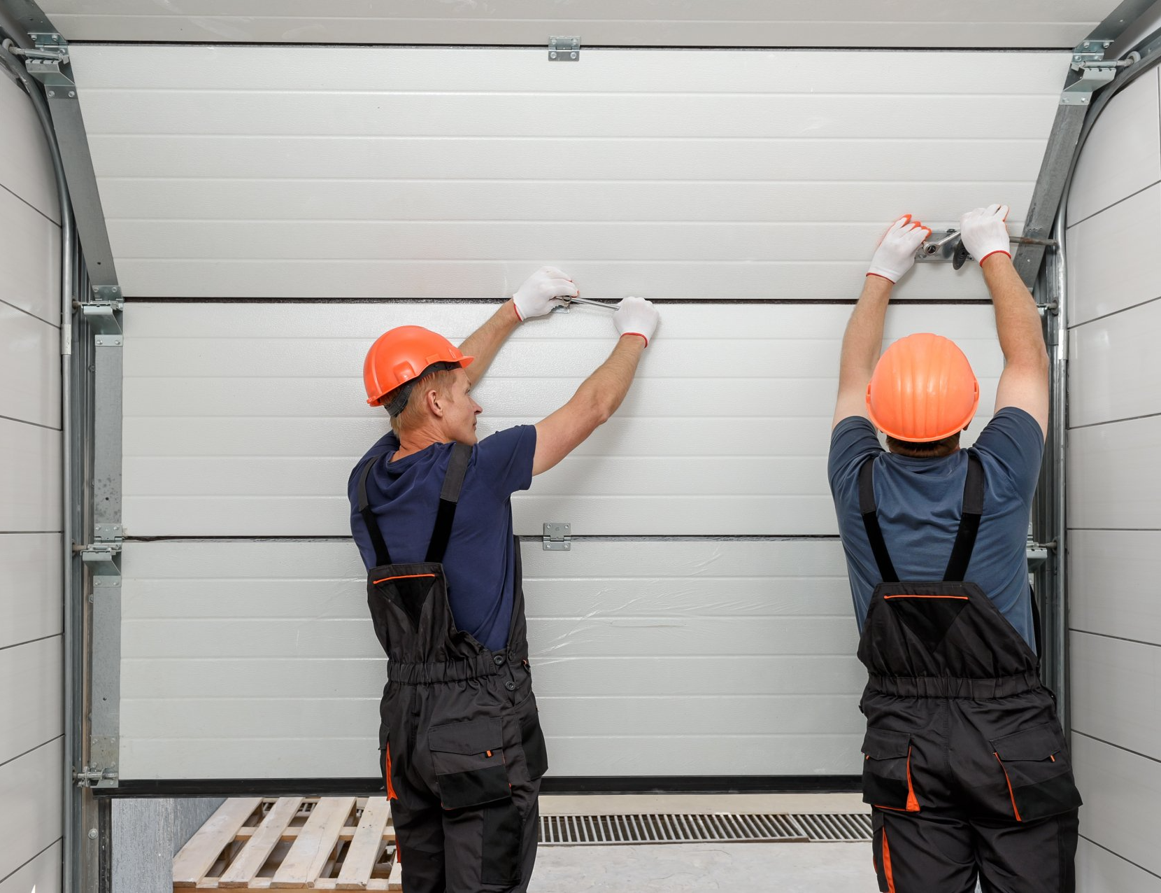 Workers are installing lifting gates of the garage.