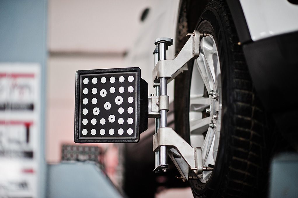 A car wheel is being adjusted by a machine in a garage.