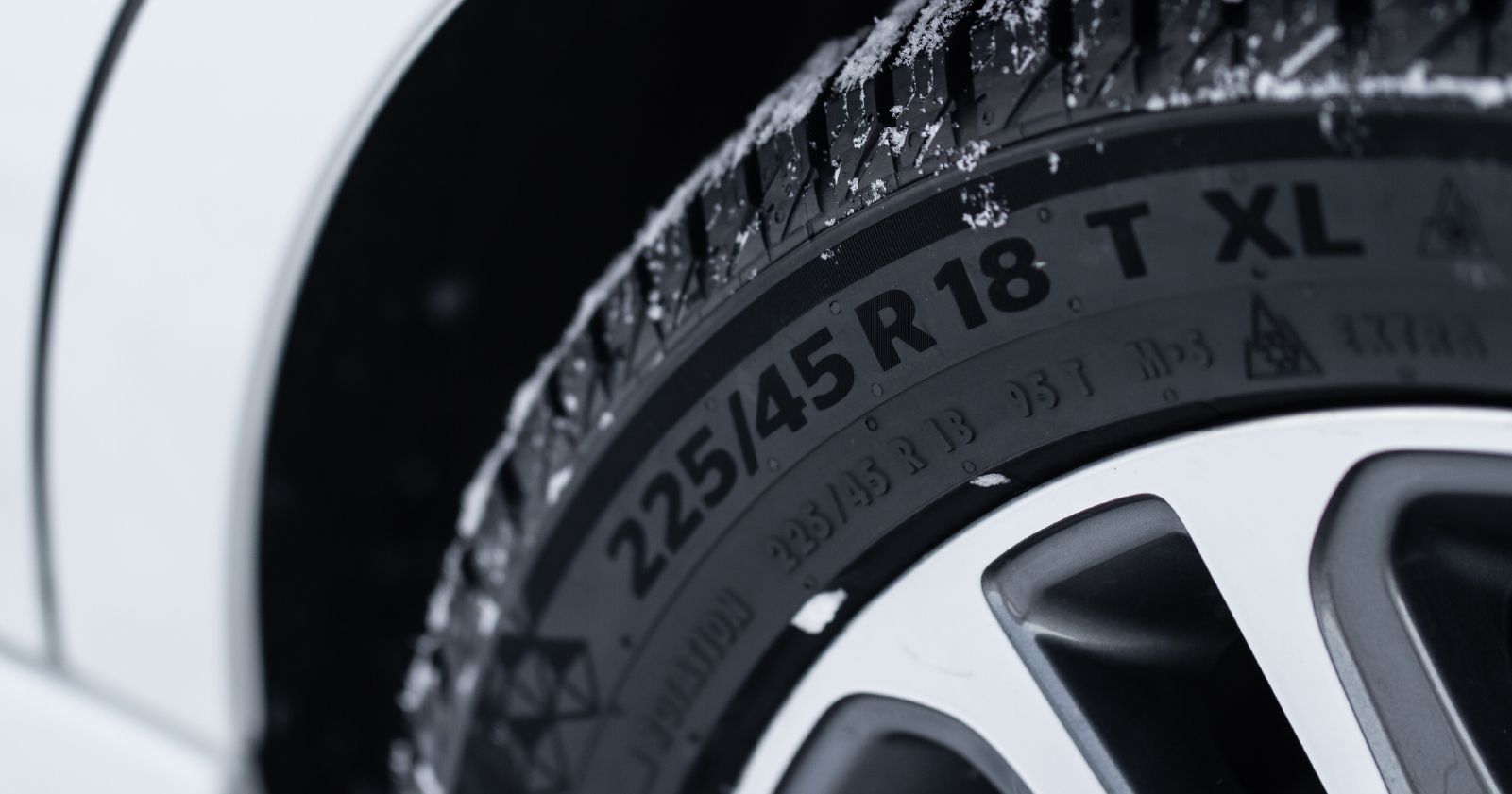 a close up of a tire that says 225 / 45r18 t xl to accompany a tire sizing guide article