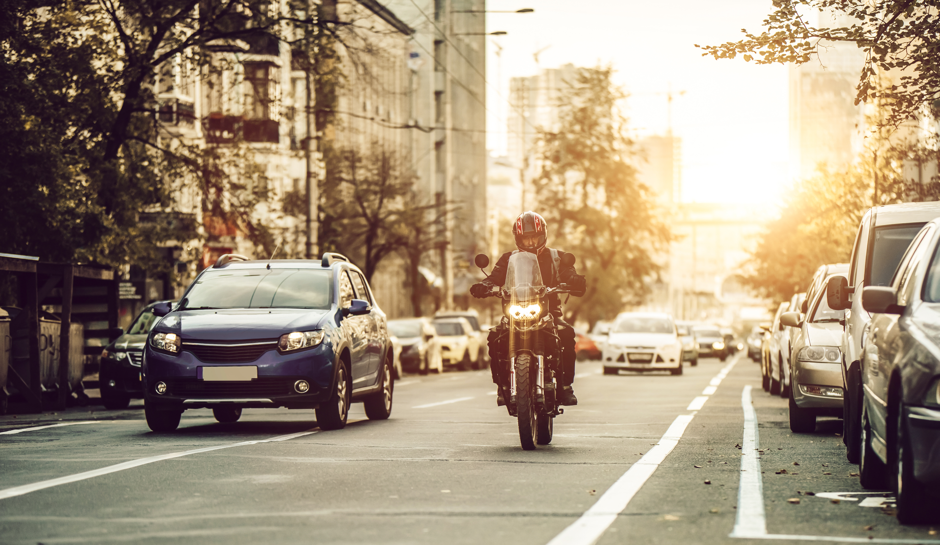A man is riding a motorcycle down a city street.