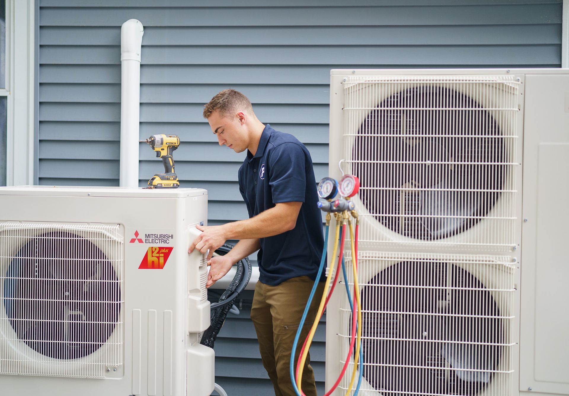 Prevett Heating and Cooling |A man is working on an air conditioner outside of a house.