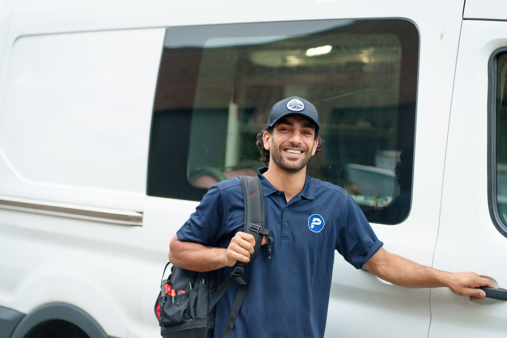 Prevett Heating and Cooling |A man in a blue shirt is standing next to a white van.