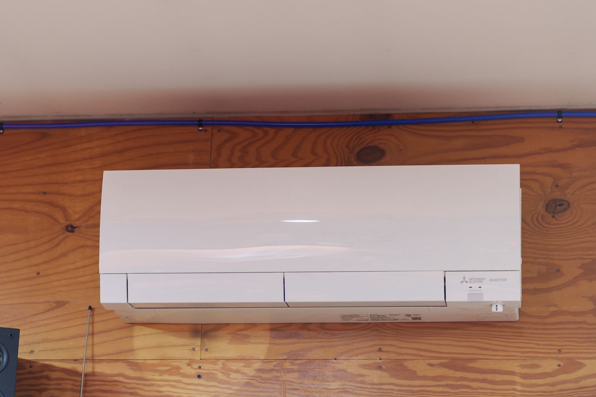 Prevett Heating and Cooling |A white air conditioner is hanging on a wooden wall.