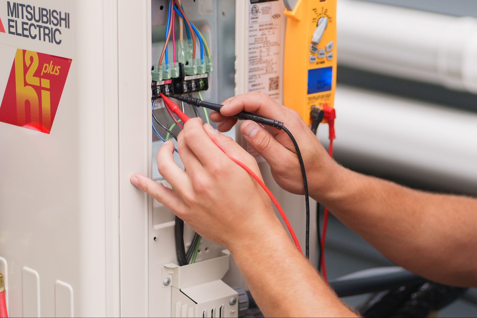 Prevett Heating and Cooling |A person is working on a Mitsubishi electric electrical box.