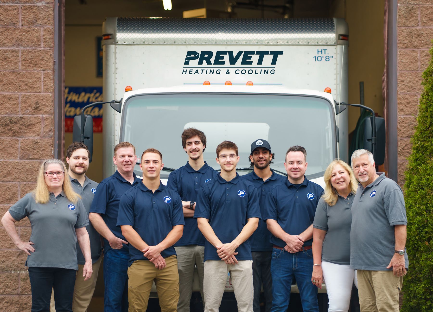 Prevett Team posing for a picture in front of a truck.