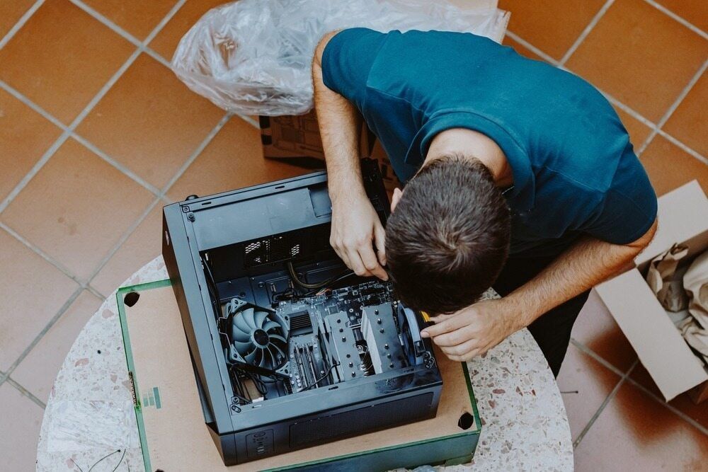 A Man Is Working On A Computer Case On A Table β Oz Data Tech in Forster, NSW