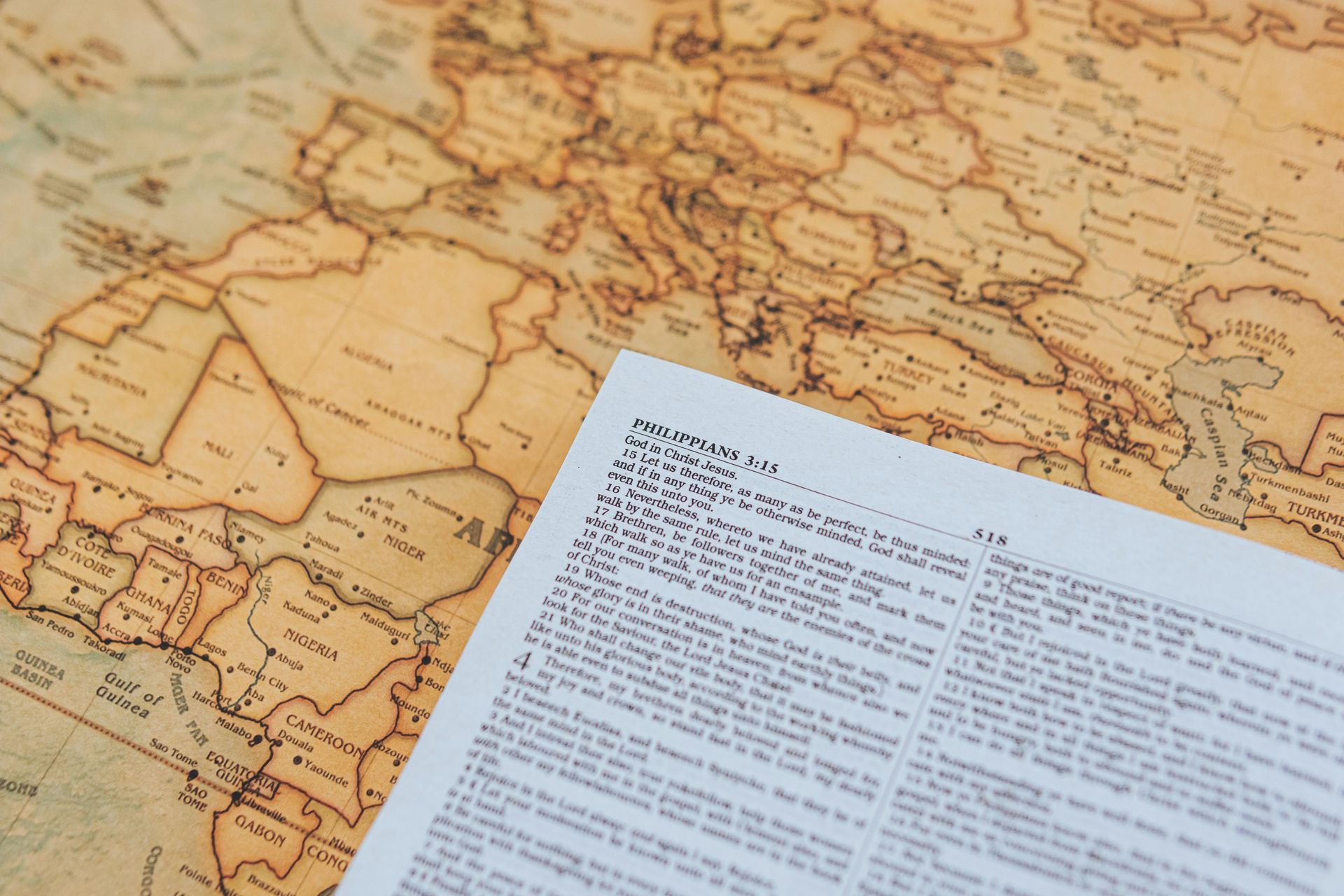 A Bible open to Philippians, on top of a world map of the world. 