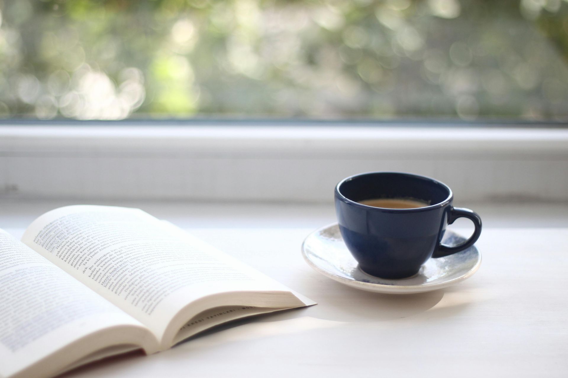A Bible open, perhaps to Colossians, next to a cup of coffee. 