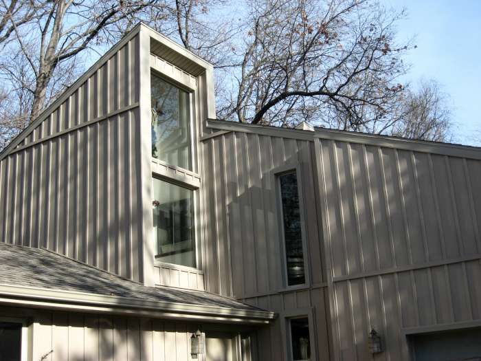 Modern building exterior with vertical wood siding and tall narrow windows under bare trees