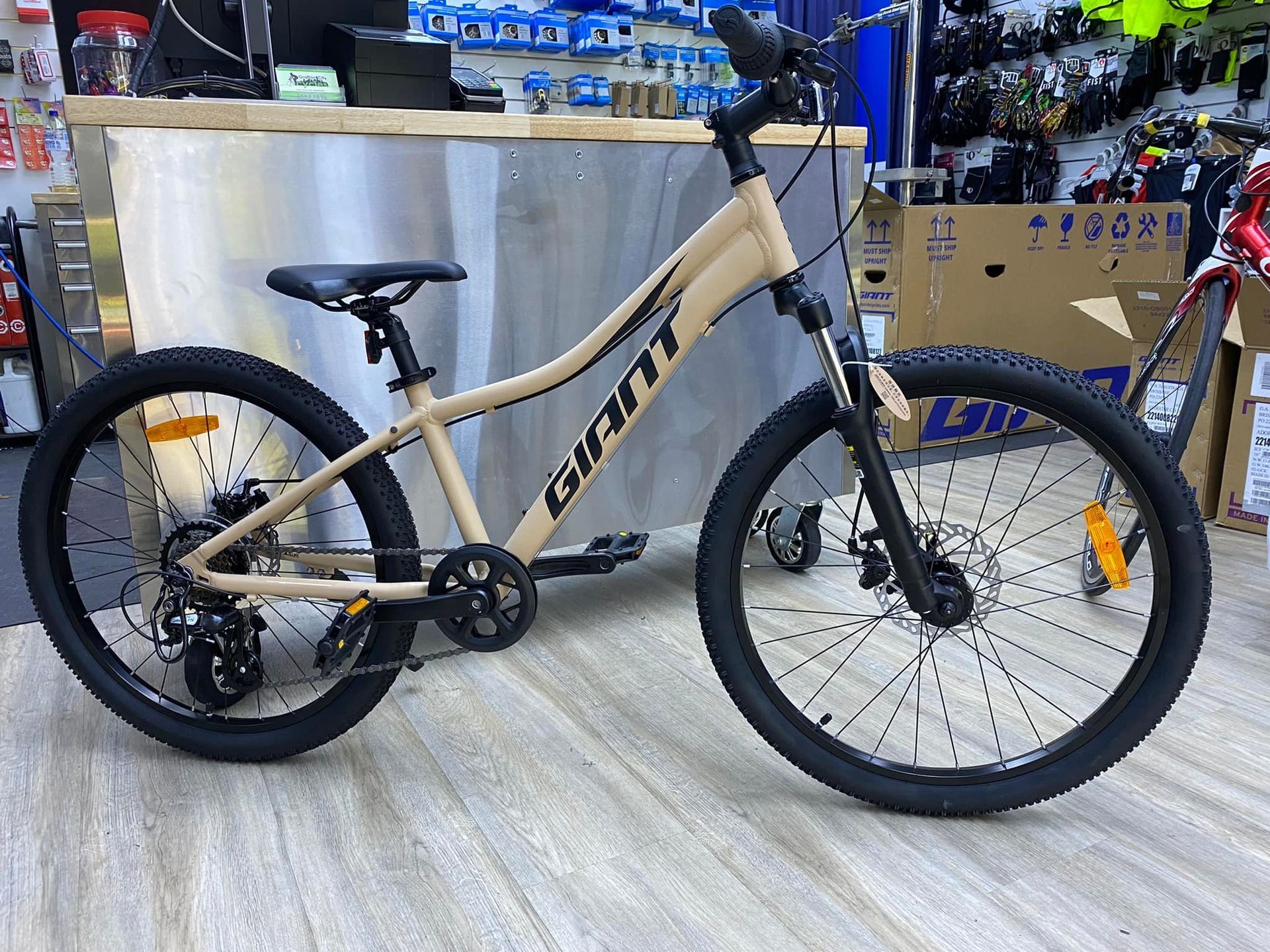 Tan Giant mountain bike with black tires and accents, on display in a store — Grafton City Cycles in Grafton, NSW