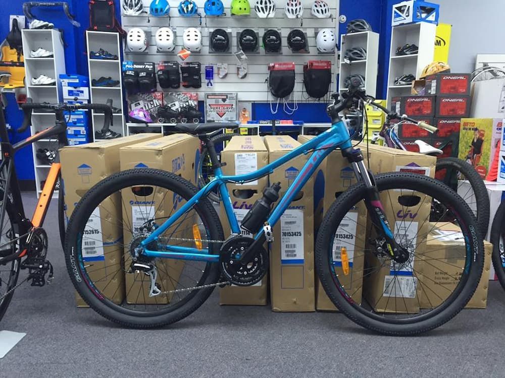 Blue mountain bike in a bike shop, surrounded by boxes and cycling gear — Grafton City Cycles in Grafton, NSW