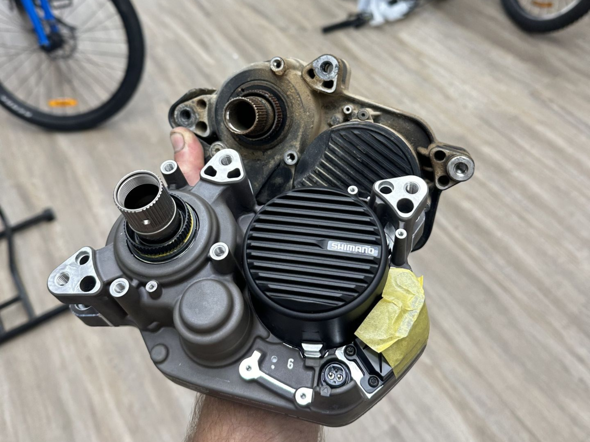 Hand holding a disassembled e-bike motor; exposed gears and components — Grafton City Cycles in Grafton, NSW