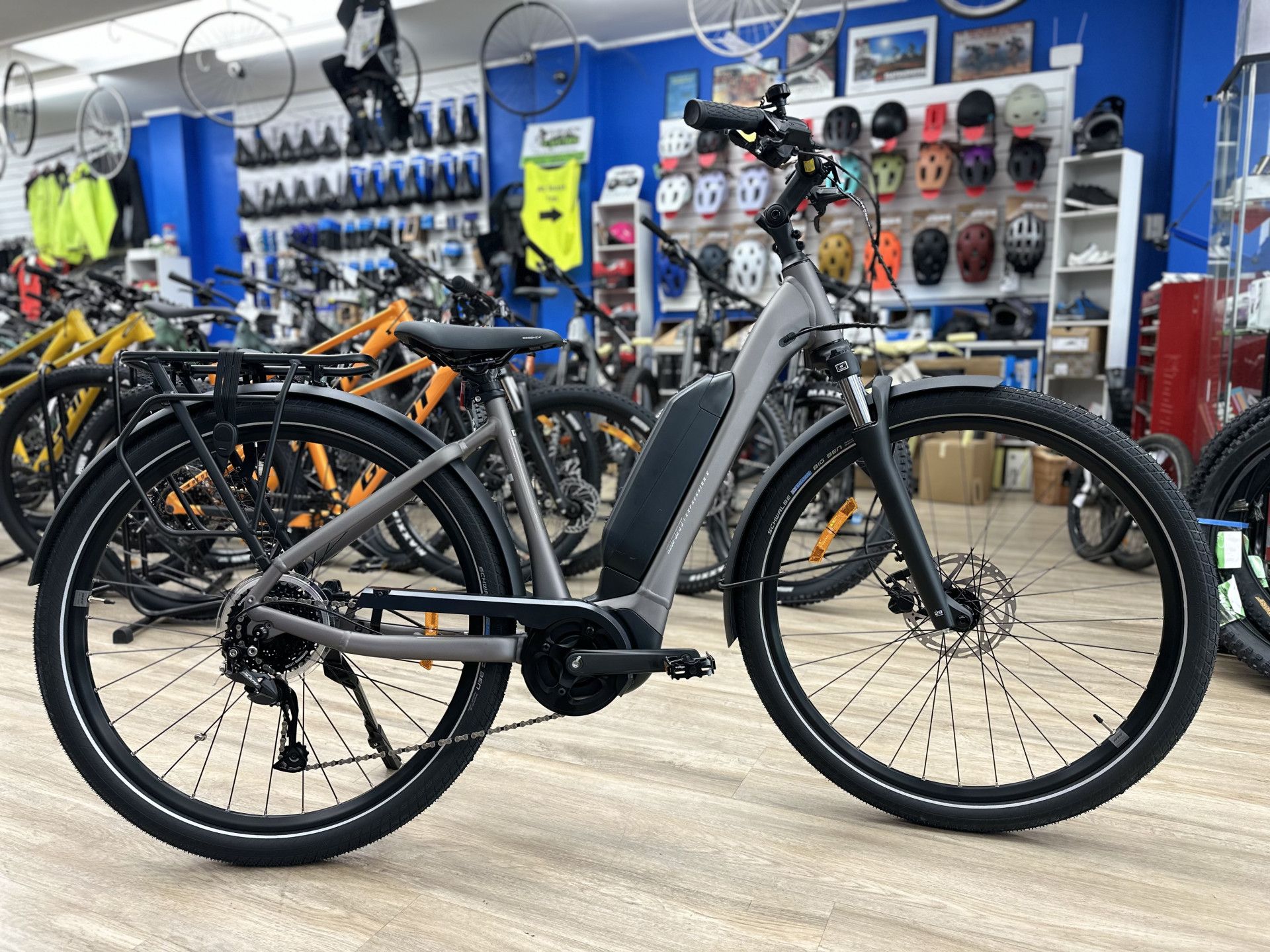 Gray electric bike with a rack parked inside a bike shop, other bikes in background — Grafton City Cycles in Grafton, NSW