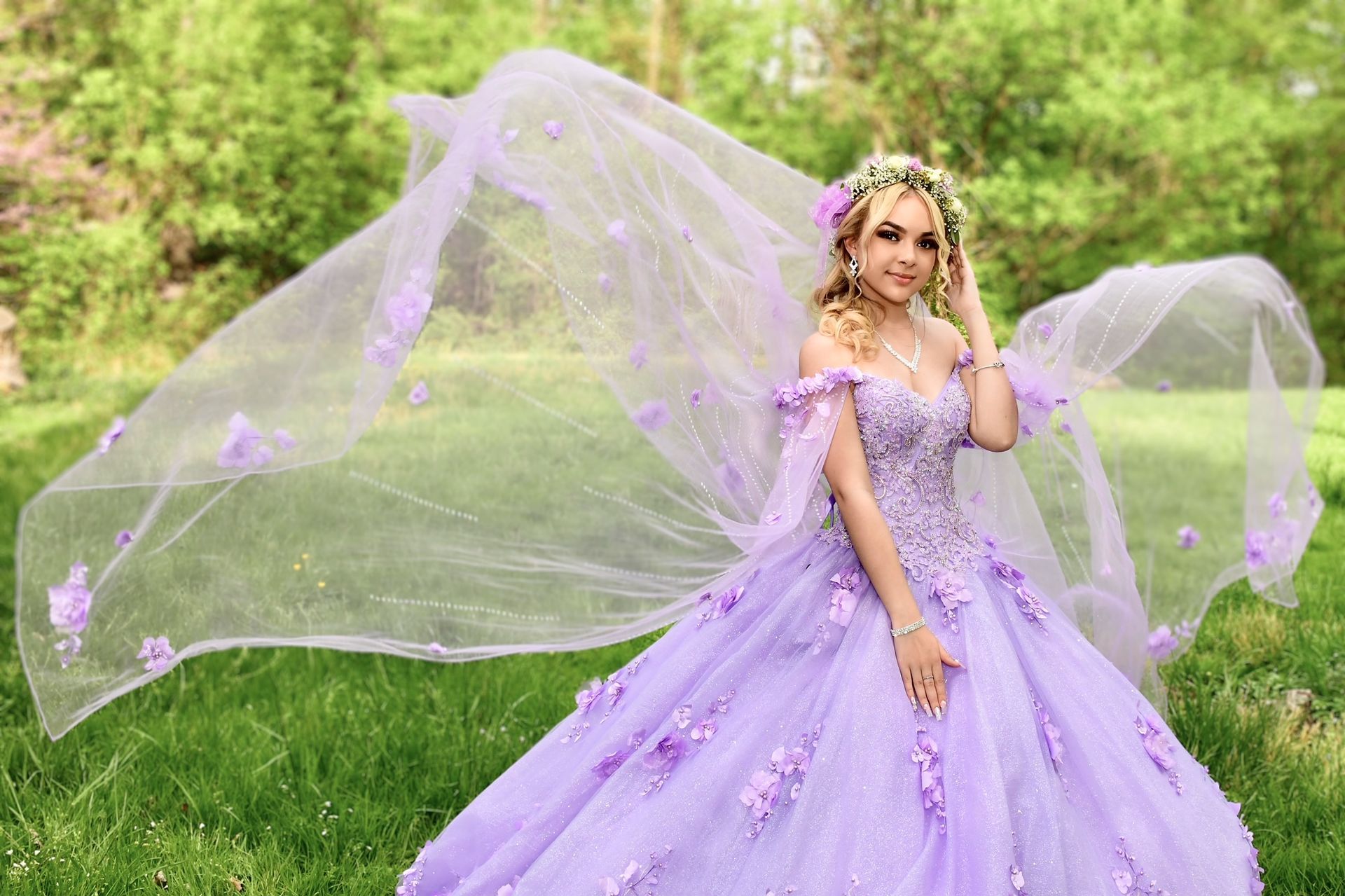 Modern kitchen with gray cabinets, marble countertops, stainless steel appliances, and silver pendant lights.