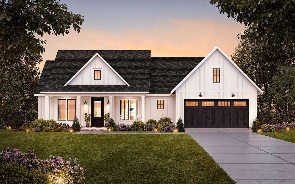 A white house with a black roof and a black garage door.