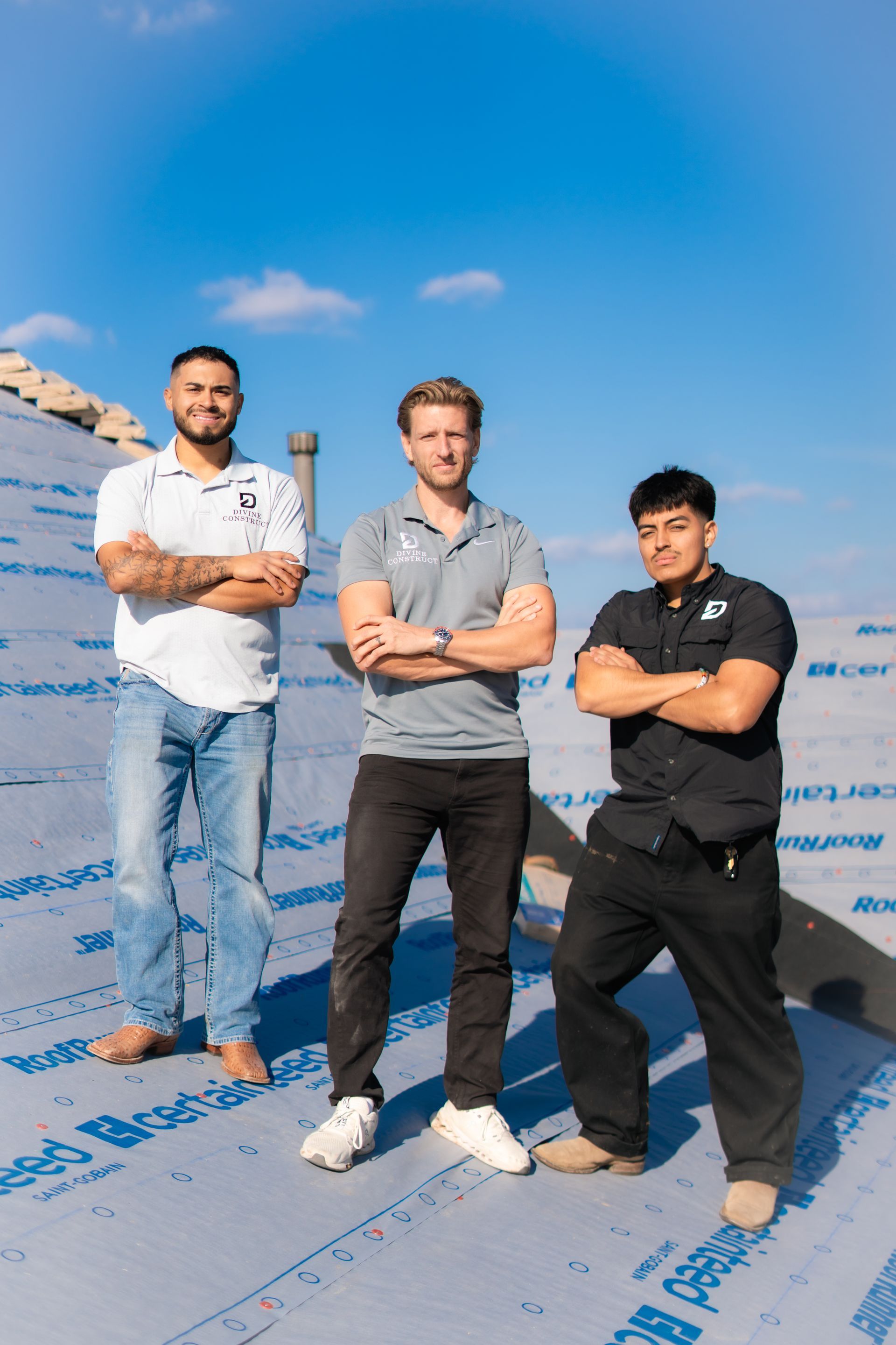 Garett Howell wearing a grey blazer, blue shirt, and khaki pants poses with hands in pockets.