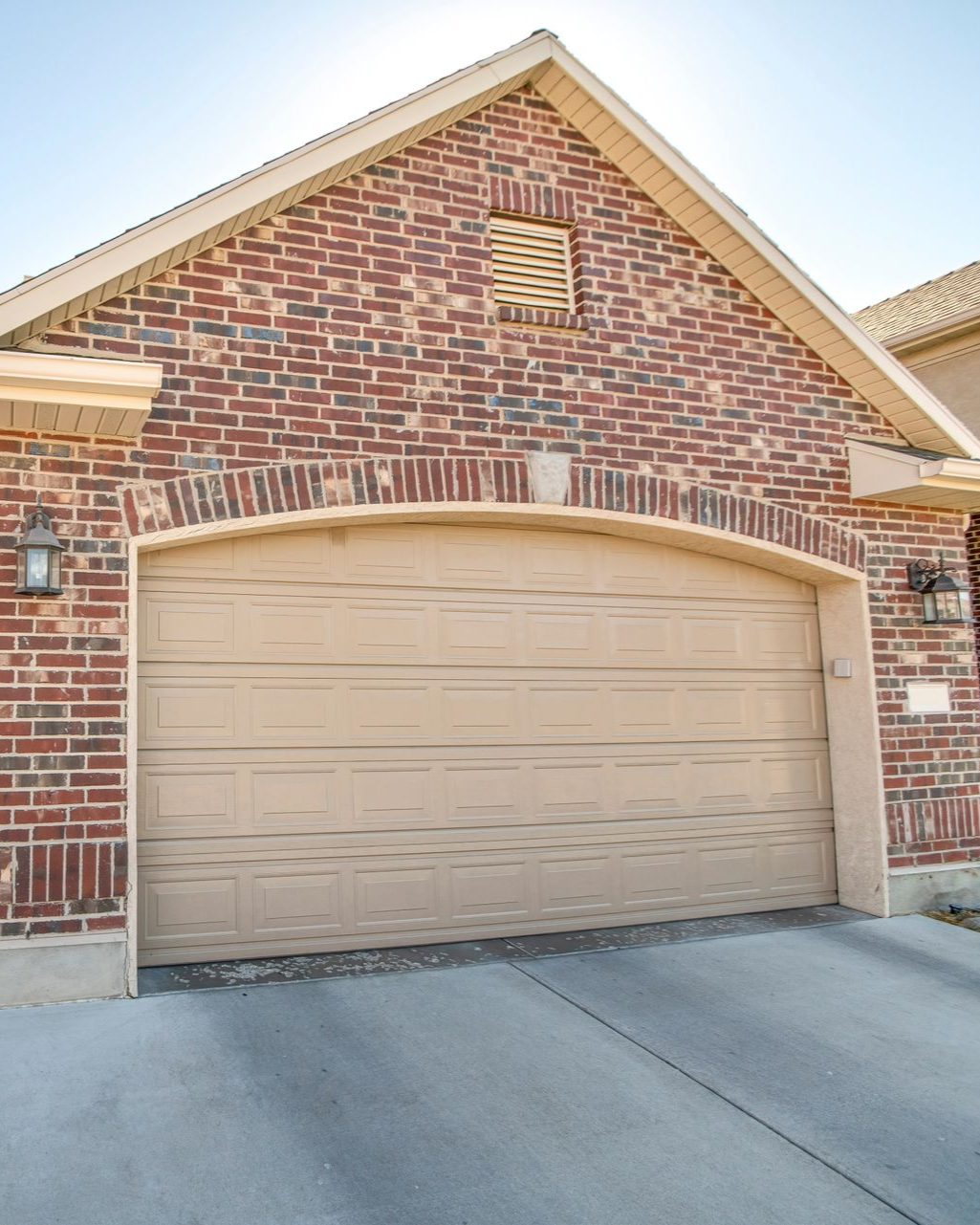 Brick garage with tan door and trim.