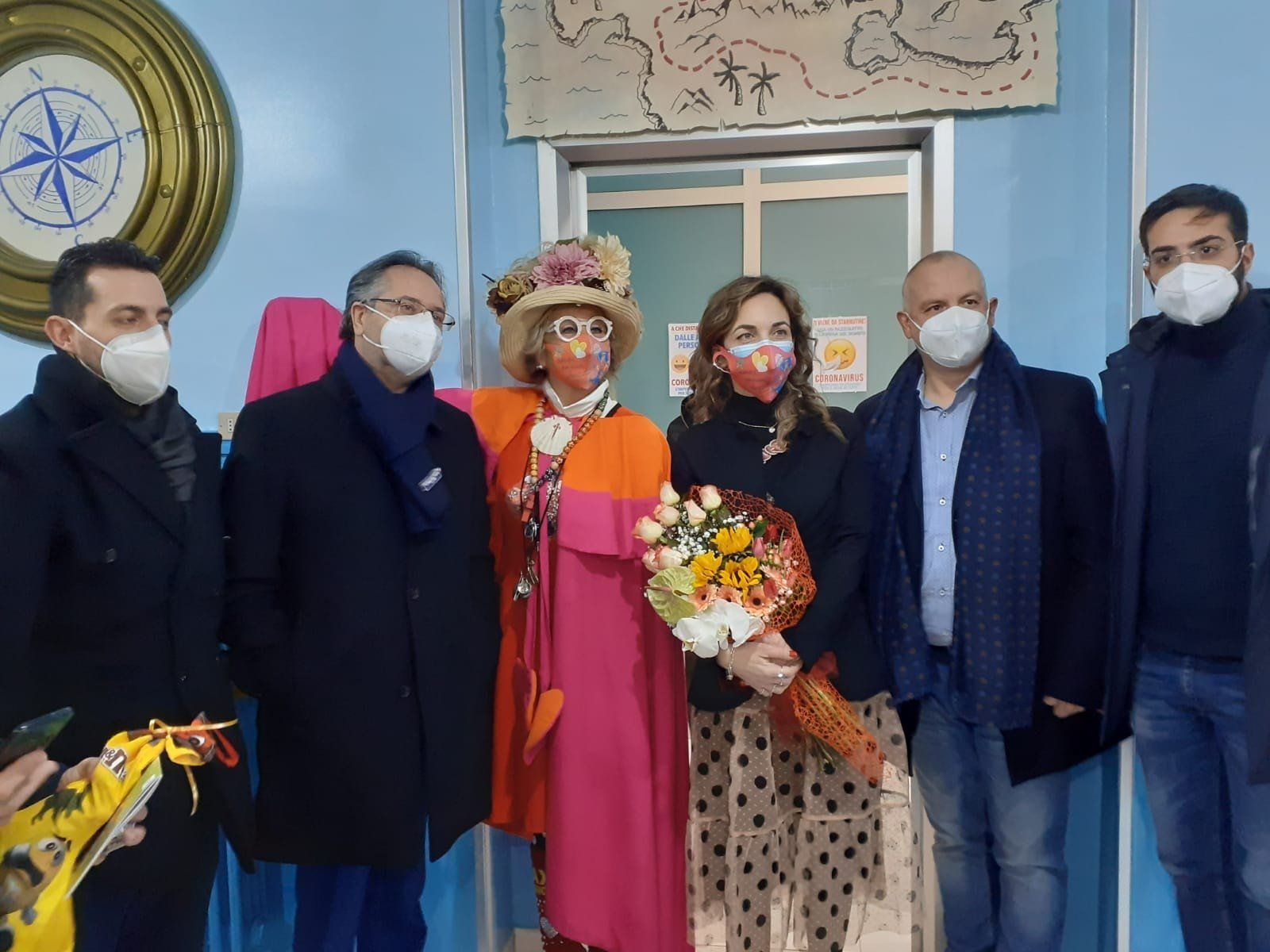 Un gruppo di persone che indossano maschere stanno posando per una foto.