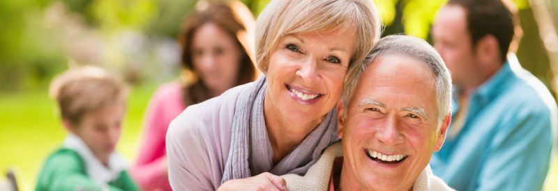 A group of people are posing for a picture in a park.