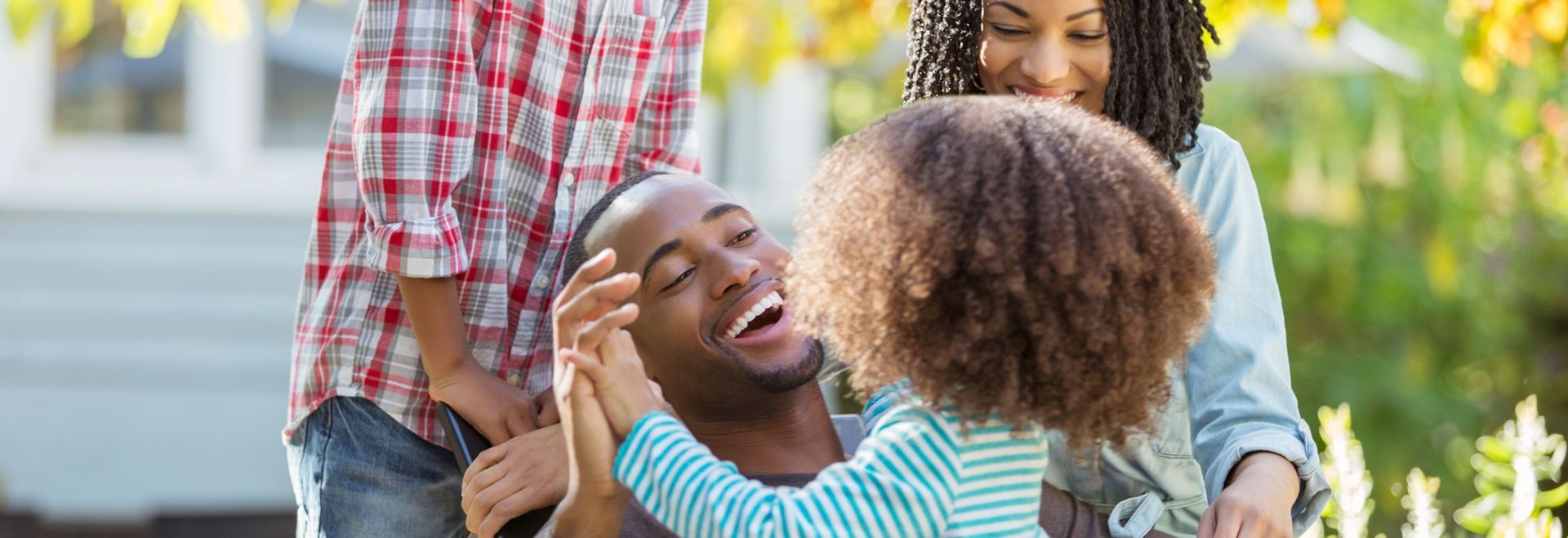 A man and woman are holding a little girl in their arms.
